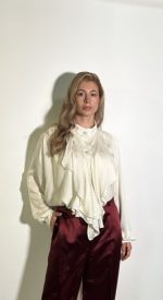 Camicetta da donna raso lucido bianca a pois.Modello con maniche lunghe con bottoni sul polsino e chiusura frontale detaglio volant sul davanti. Taglia Unica
