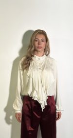 Camicetta da donna raso lucido bianca a pois.Modello con maniche lunghe con bottoni sul polsino e chiusura frontale detaglio volant sul davanti. Talia Unica