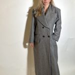 Cappotto grigio pied de poule da donna lungo alla caviglia con design elegante doppiopetto colo a revers e maniche lunghe.Il capo e realizzato in caldo panno di misto lana ottenuto da filati rigenerati che danno alla struttura un aspetto mosso i irregolare,ed e personalizzato con doppio tasche da una parte sottolineando il girovita modello foderato viscosa. Taglia unica