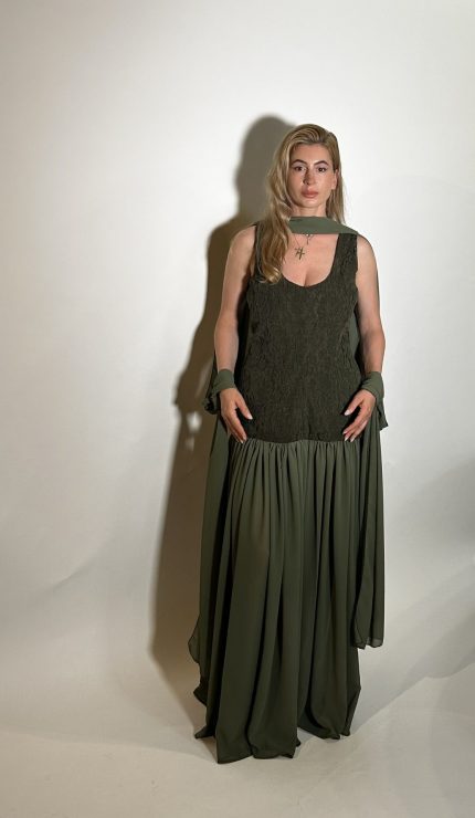 Abito lungo verde oliva realizzato in georgette leggera, segue la silhouette con un pizzo fluido, esaltato da una gonna interamente lavorata a plisse che si apre a ogni passo. Questo abito si completa con del dettaglio sul collo la sciarpa dello stesso tessuto della gonna .Ideale per una cerimonia o una serata importante. Misure taglia M Spalle 36 cm Seno 92 cm Giro vita 48cm Fianchi 100cm Lunghezza 150 cm