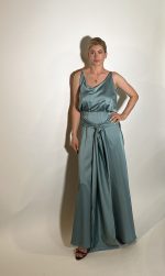 Vestito raso verde e un vestito da damigella lungo fino ai piedi realizzato in raso presenta uno scollo ampio a V davanti e uno scollo tondo dietro .Una fascia da dietro che si ports davanti con uno nodo centrale e una lunghezza che aggiunge liberta di movimento e un tocco moderno. Misure taglia M Spalle 36 cm Seno 92 cm Giro vita 48cm Fianchi 100cm Lunghezza vestito 150 cm