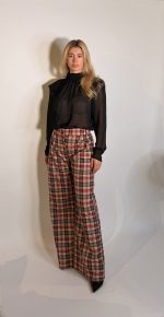 Pantalone Sheryl wide fit a vita media che interpreta le silhouette sartoriali in chiave moderna. La gamba ampia con doppie pinces ha una fluidita rilassata ,ideale per look casuali e ricercati. Realizzatoin flanella di lana con motivo checkcolor bordeaux e bianco .Paillettes cucite.