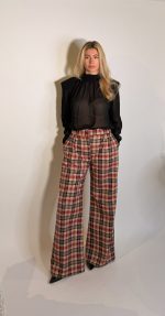 Pantalone Sheryl wide fit a vita media che interpreta le silhouette sartoriali in chiave moderna. La gamba ampia con doppie pinces ha una fluidita rilassata ,ideale per look casuali e ricercati. Realizzatoin flanella di lana con motivo checkcolor bordeaux e bianco .Paillettes cucite.