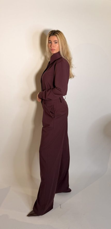 Pantalone dal design sartoriale e contemporaneo caratterizzato da una silhouette ampia e fluida e da una linea elegante e strutturata. Il modello presenta vita regolare, pinces fontali e una gamba larga dritta che slancia la figura mantenendo un estetica essenziale e sofisticata.